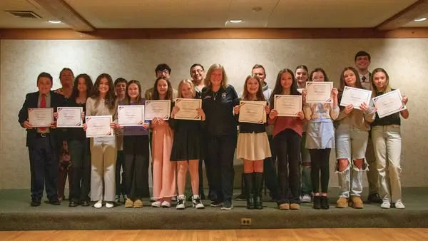 Youth award winners holding certificates on stage